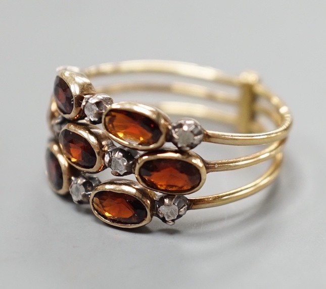 A late Victorian yellow metal, garnet and diamond chip cluster set triple shank ring, size M, gross weight 3.6 grams.